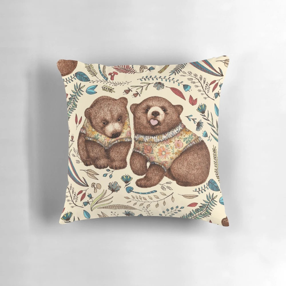 A decorative throw pillow featuring a whimsical illustration of two brown bear cubs surrounded by fantastical forest flora.