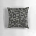 Whimsical illustration of a suspicious-looking black cat on a decorative throw pillow
