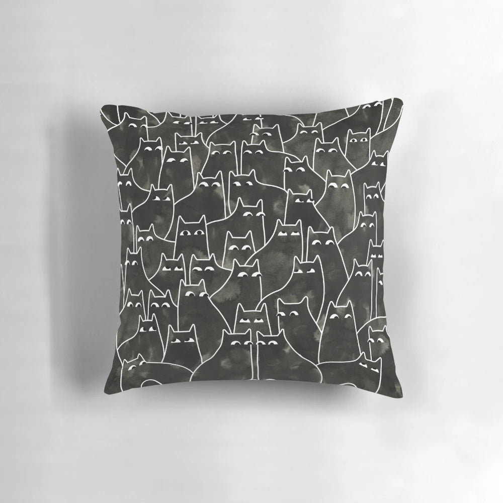 Whimsical illustration of a suspicious-looking black cat on a decorative throw pillow