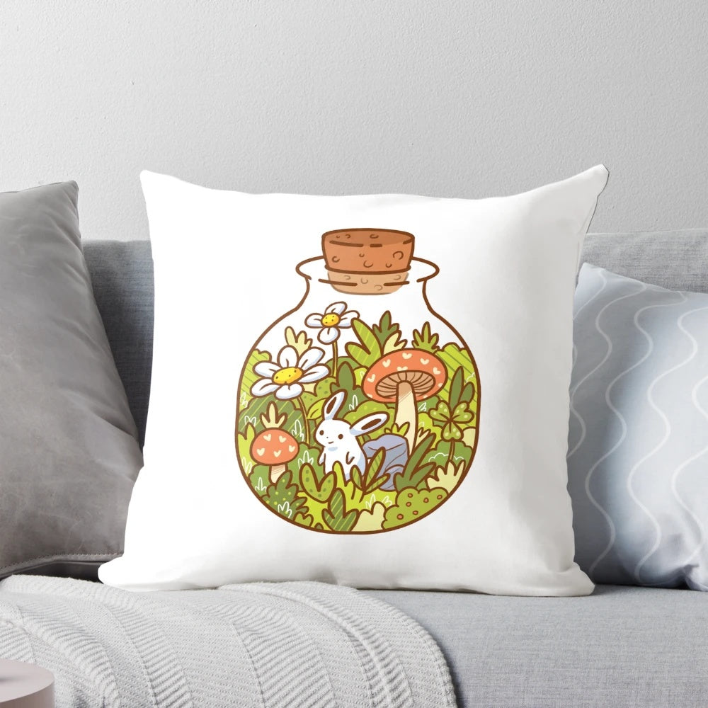 A soft, plush pillow featuring a delightful bunny in a glass bottle, surrounded by lush foliage and nature-inspired elements.