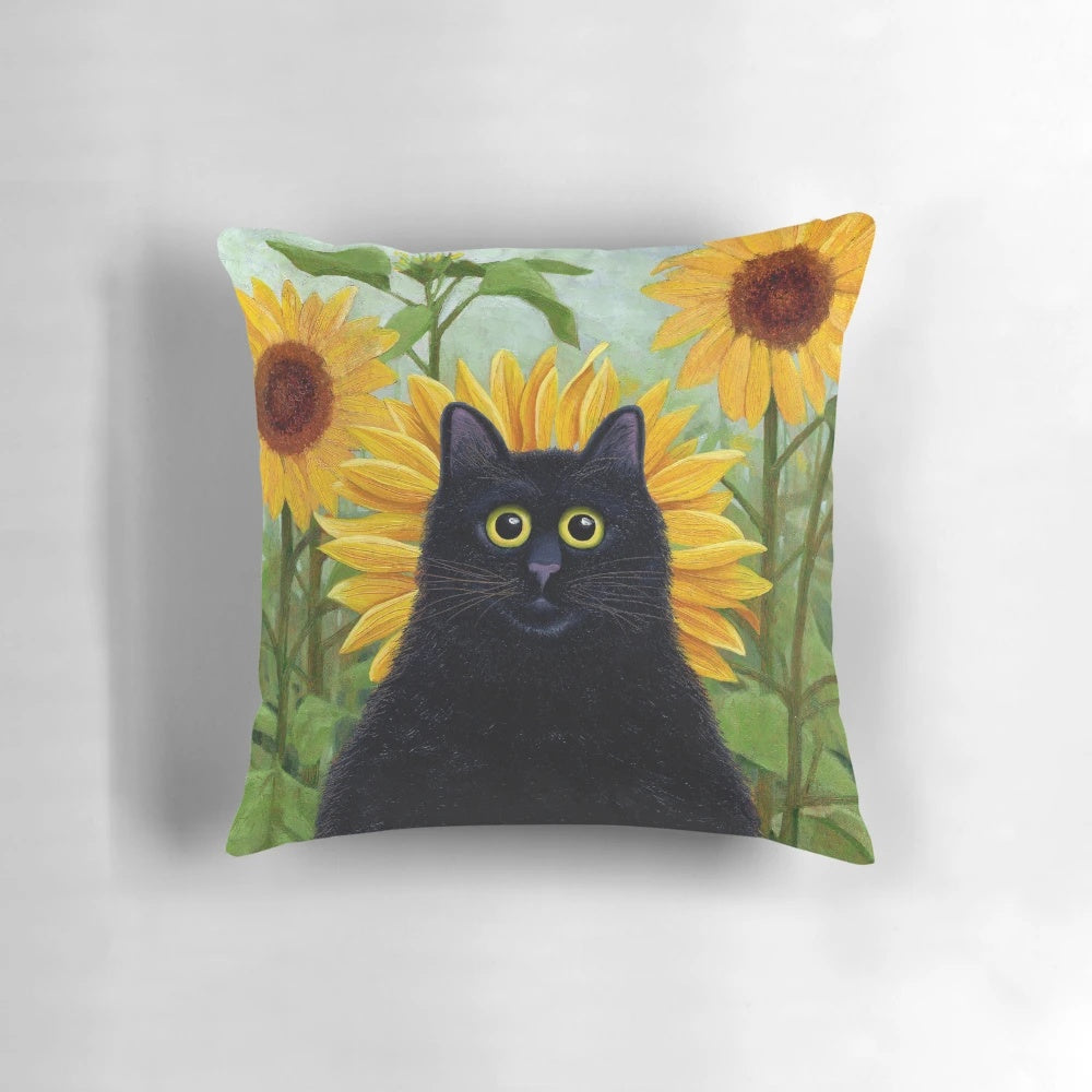 A decorative black cat pillow featuring a playful design with dandelions and sunflowers