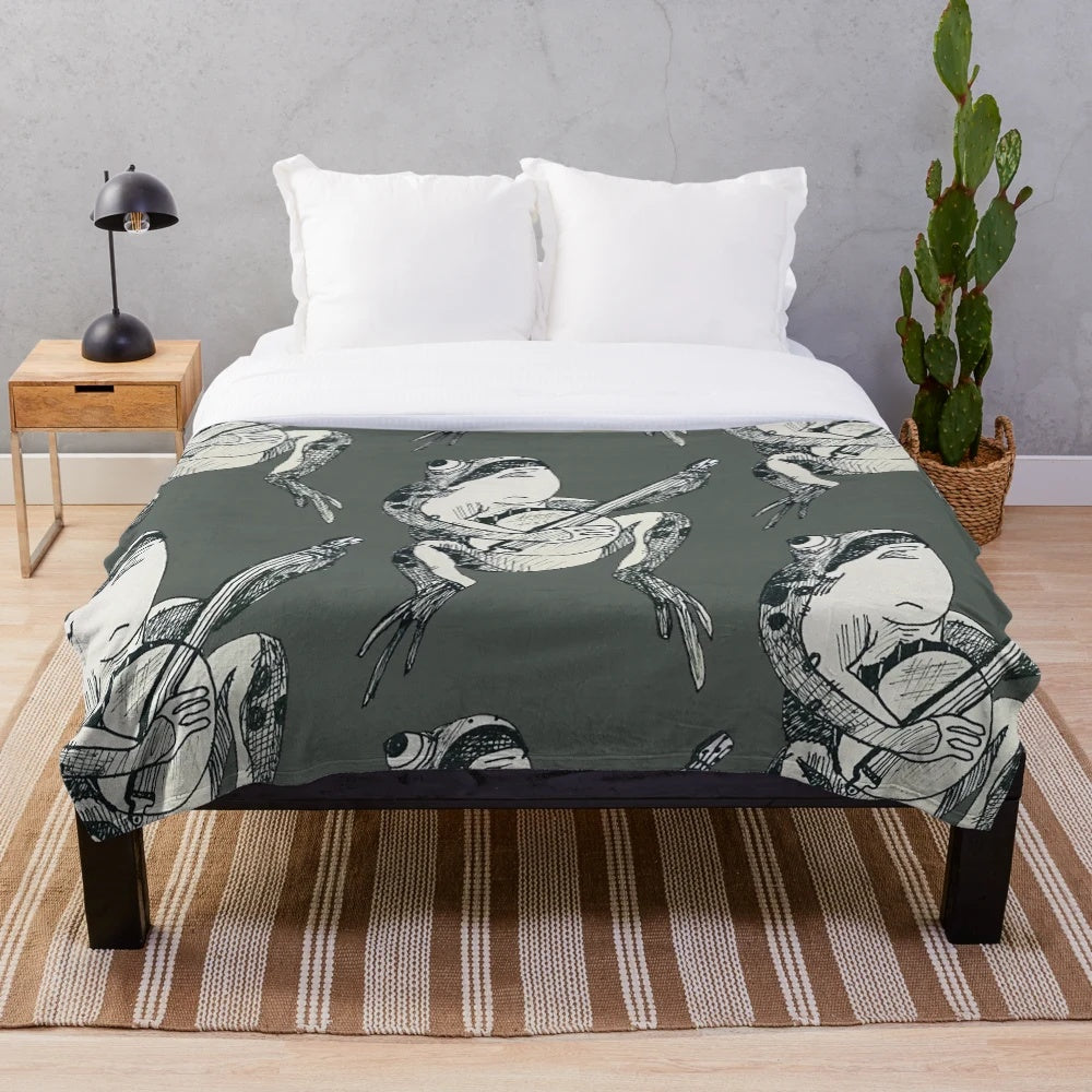 A plush blanket featuring a whimsical fairytale frog playing a banjo in a woodland setting