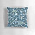 A decorative throw pillow featuring a colorful, folk-inspired dinosaur design in shades of blue.