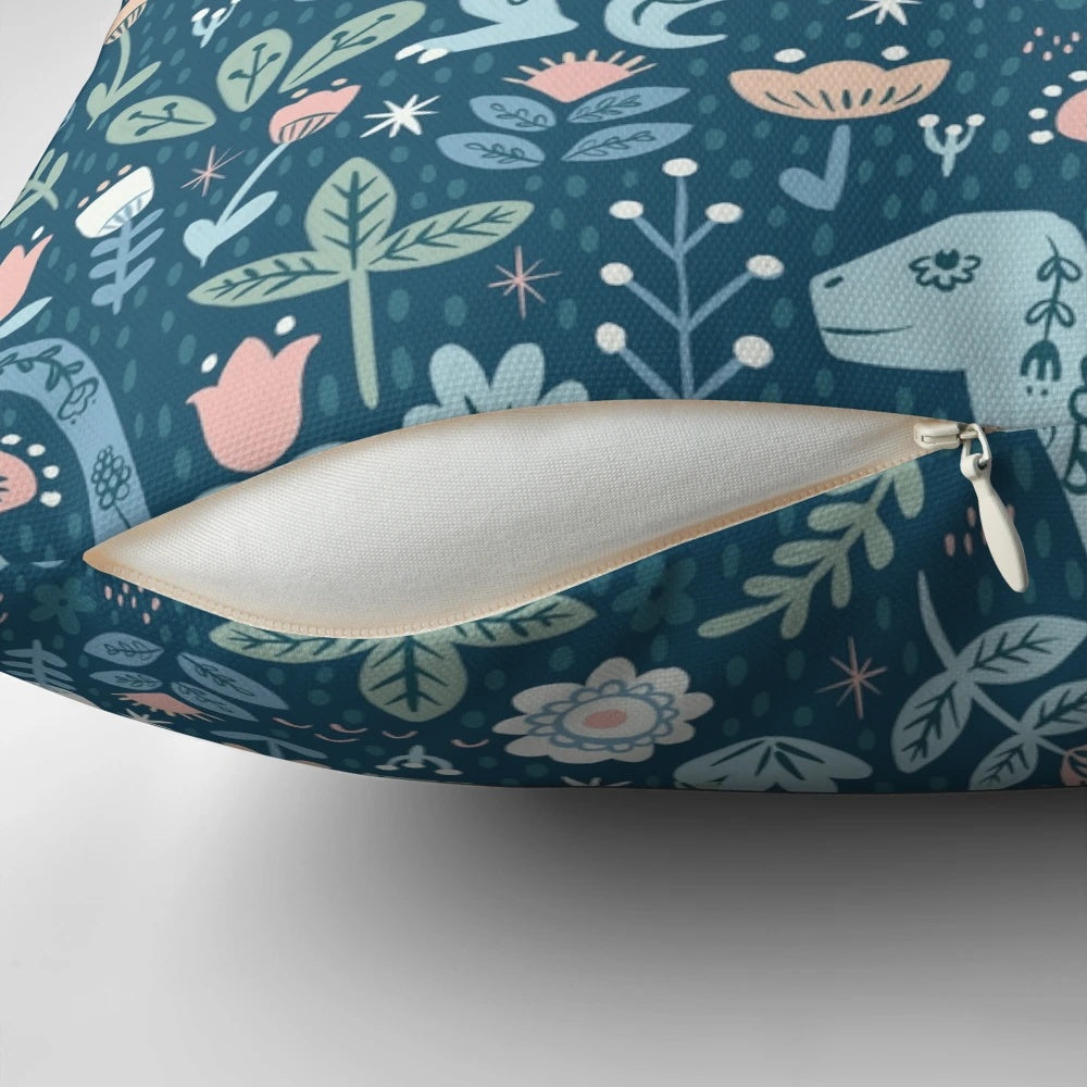 A decorative throw pillow featuring a colorful, folk-inspired dinosaur design in shades of blue.