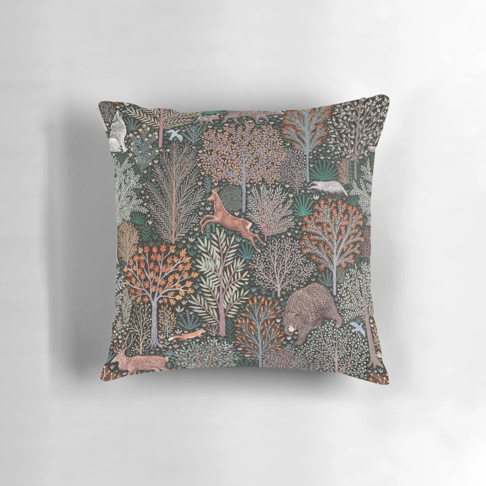 Decorative pillow featuring an illustration of forest animals like bears, deer, and wild boar amongst autumn leaves and trees.