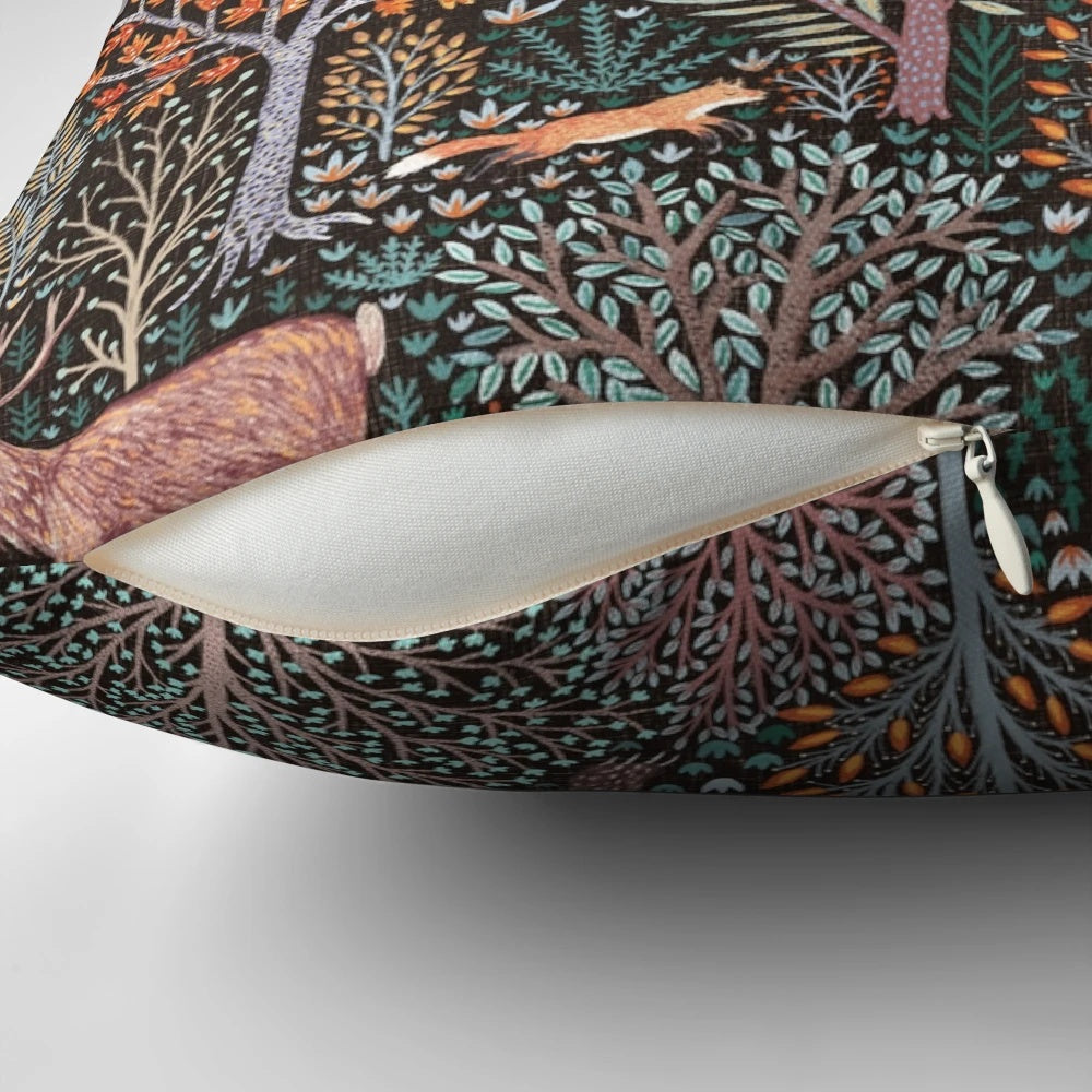 Decorative pillow featuring an illustration of forest animals like bears, deer, and wild boar amongst autumn leaves and trees.