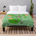 Whimsical frog plush blanket in green and pink floral design