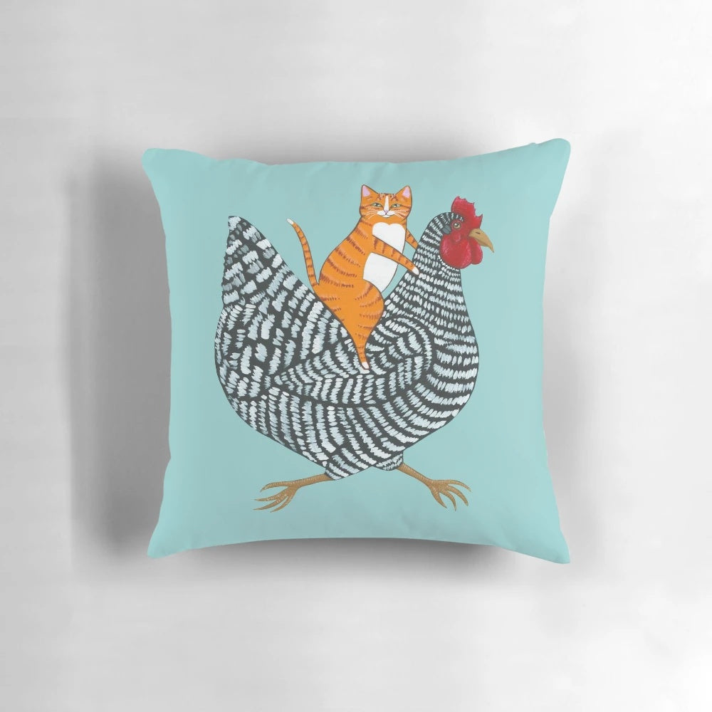 Ginger cat sitting on a barred chicken, creating a whimsical and humorous folk art-inspired product image.