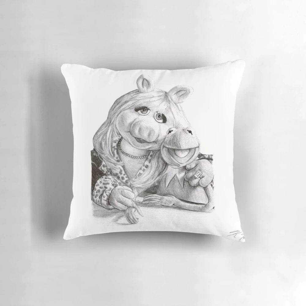 A plush decorative pillow featuring the beloved Muppet characters Kermit the Frog and Miss Piggy in a fun ballpoint pen design.