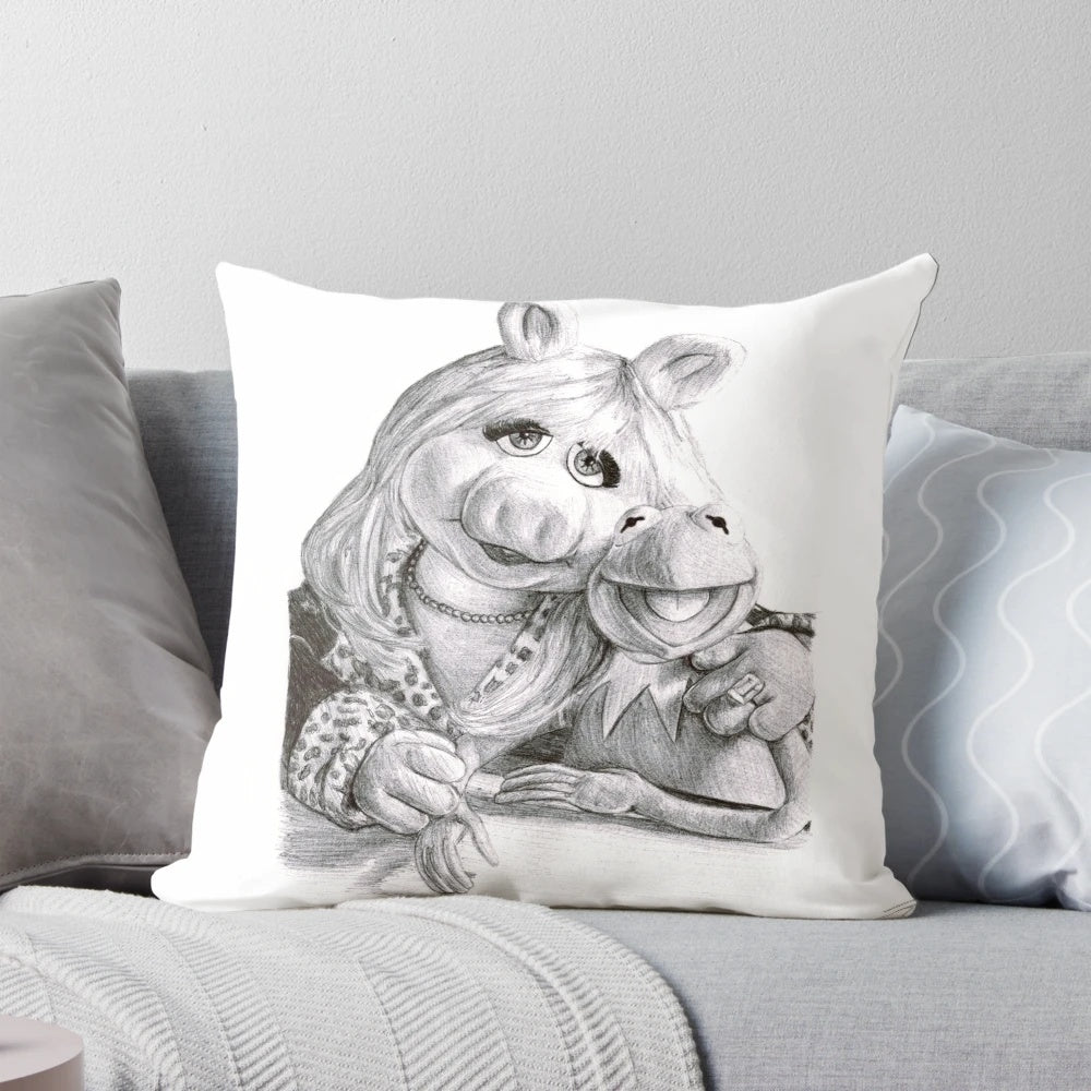 A plush decorative pillow featuring the beloved Muppet characters Kermit the Frog and Miss Piggy in a fun ballpoint pen design.