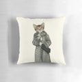 A white and orange kitten wearing a leopard print dress and posing on a pillow
