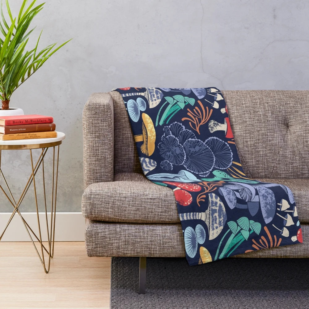 Plush blanket with multicoloured wild mushroom illustrations on a midnight blue background