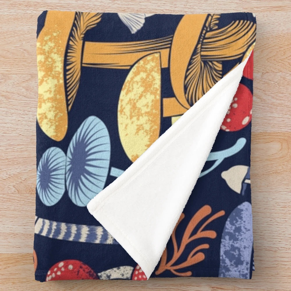 Plush blanket with multicoloured wild mushroom illustrations on a midnight blue background