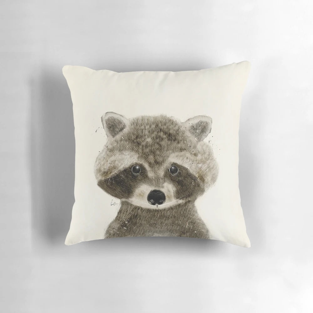 Whimsical watercolor illustration of a cute raccoon on a plush pillow, perfect for nature inspired home decor or a child's nursery.