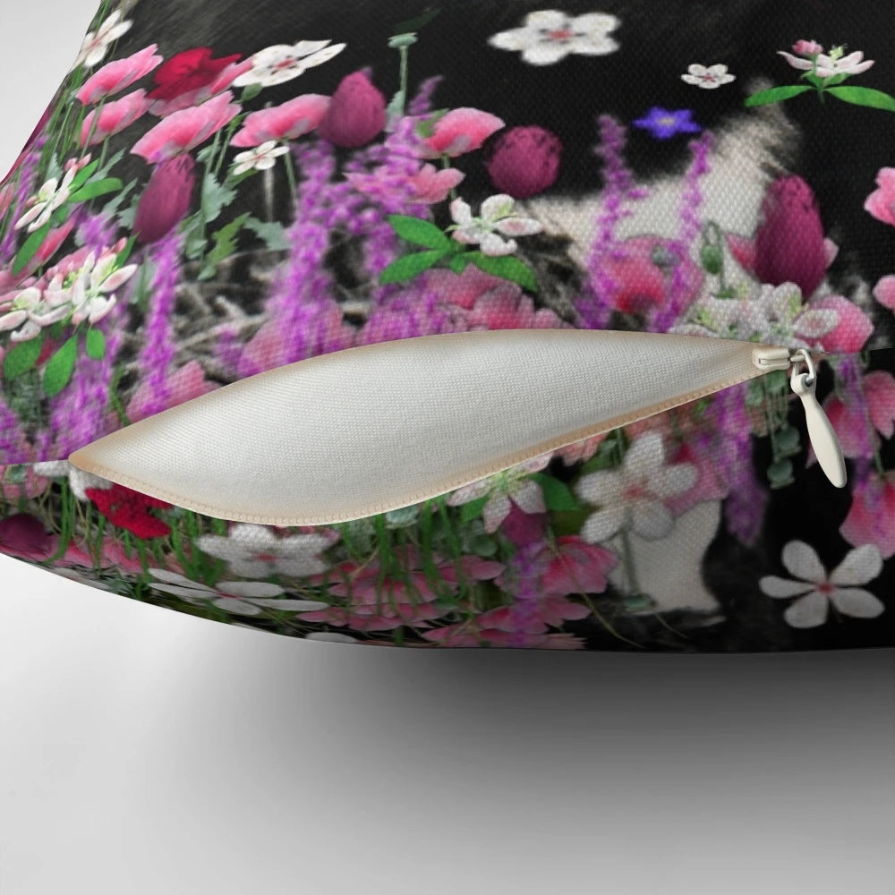 A whimsical pillow featuring a tuxedo cat surrounded by a colorful floral meadow