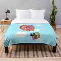 Colorful plush blanket featuring balloons and the iconic house from the Pixar movie "Up
