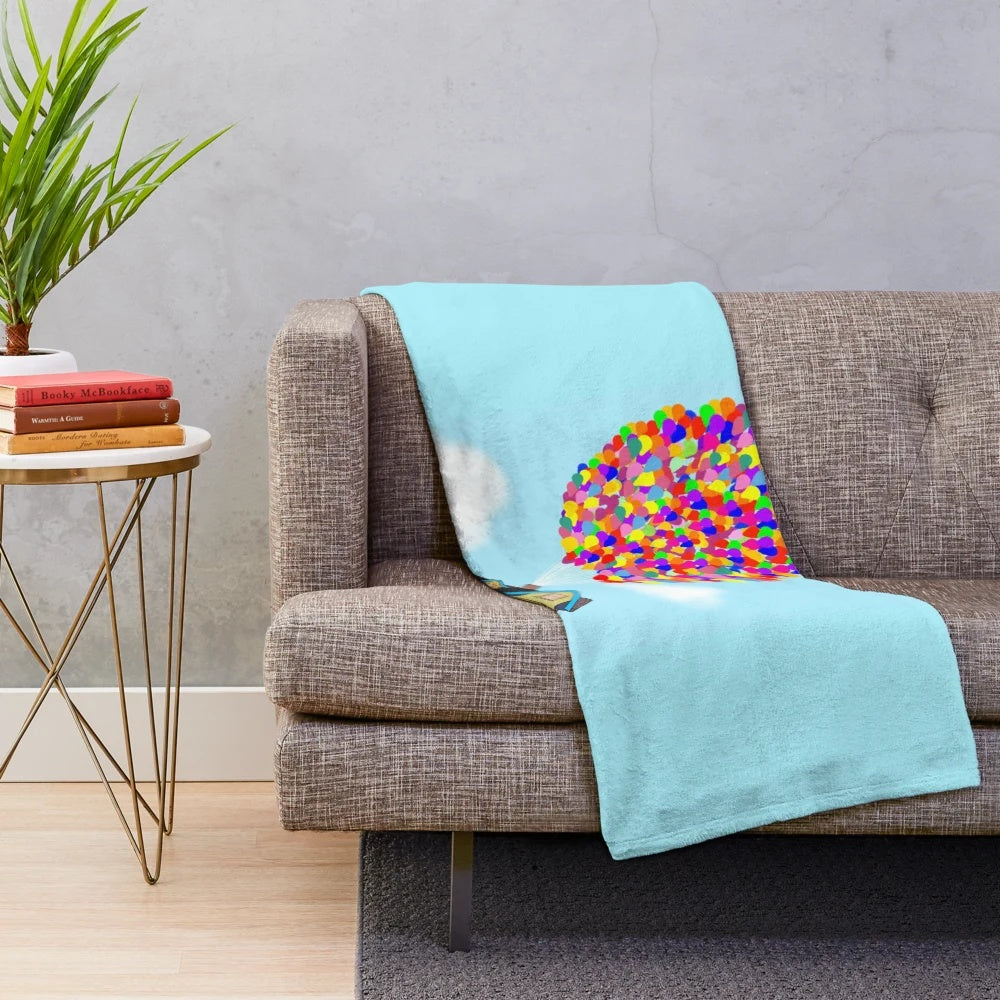 Colorful plush blanket featuring balloons and the iconic house from the Pixar movie "Up