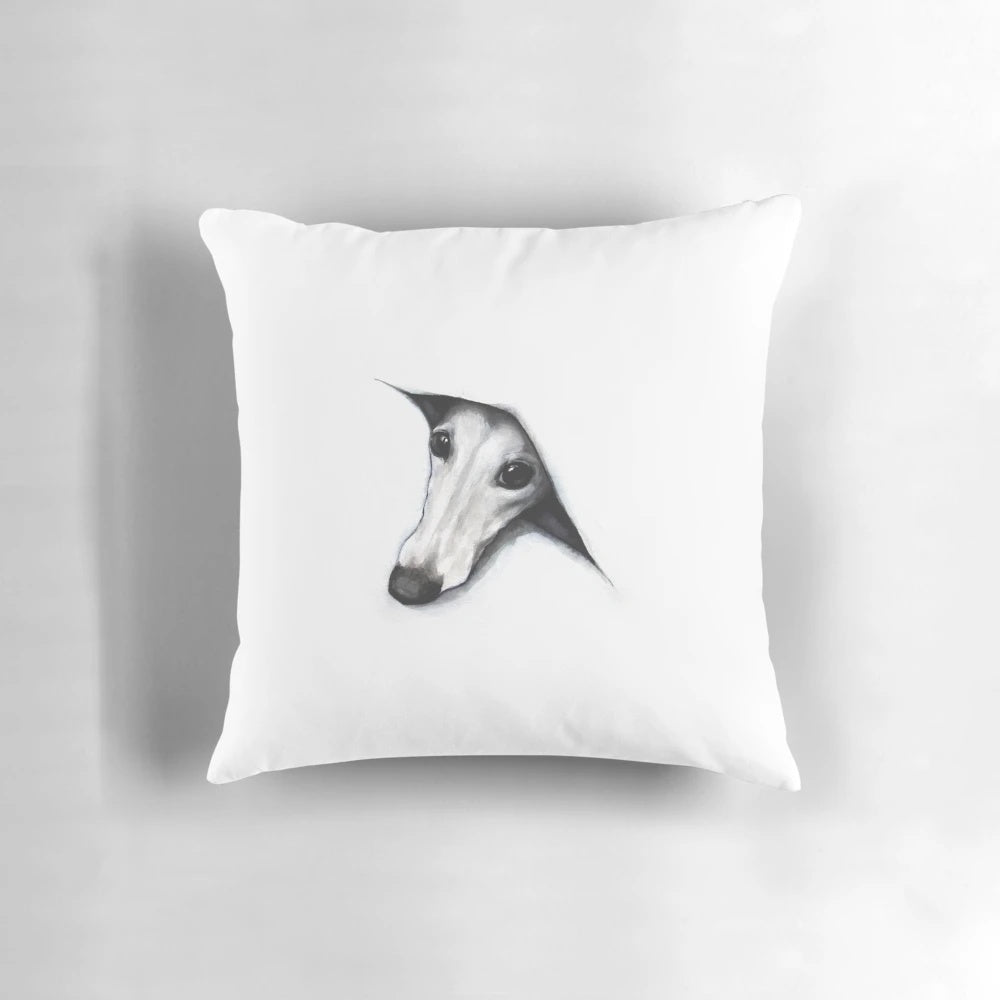 Whimsical whippet peeking out from behind a plush pillow
