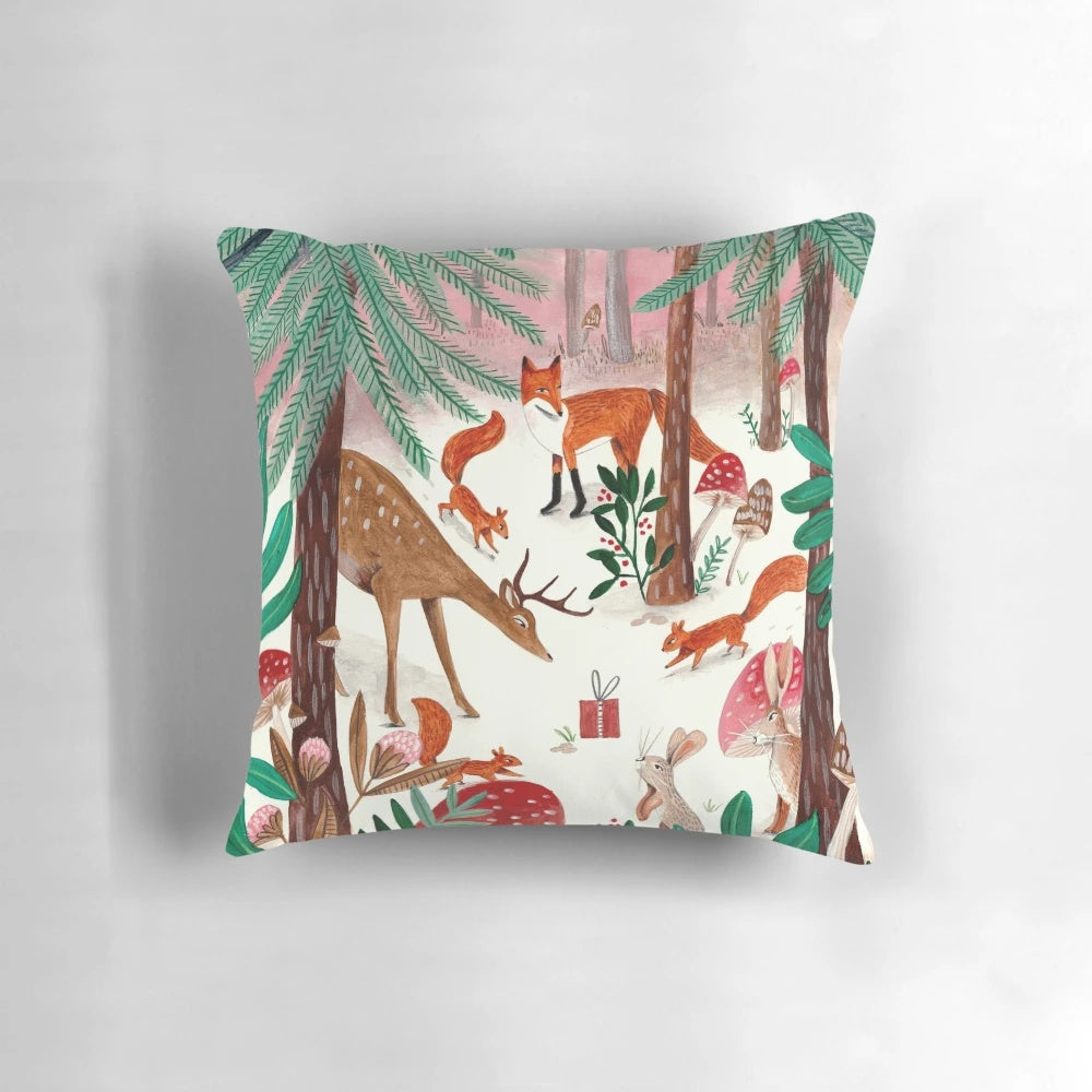 A cozy pink and green pillow featuring whimsical woodland animals in a snowy forest scene