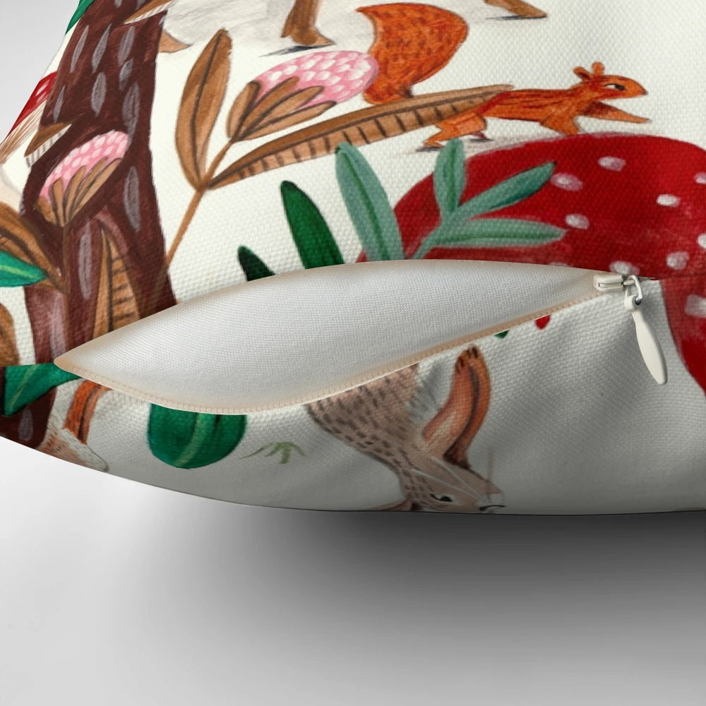 A cozy pink and green pillow featuring whimsical woodland animals in a snowy forest scene