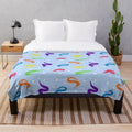 Colorful plush blanket featuring a whimsical worm on a string design