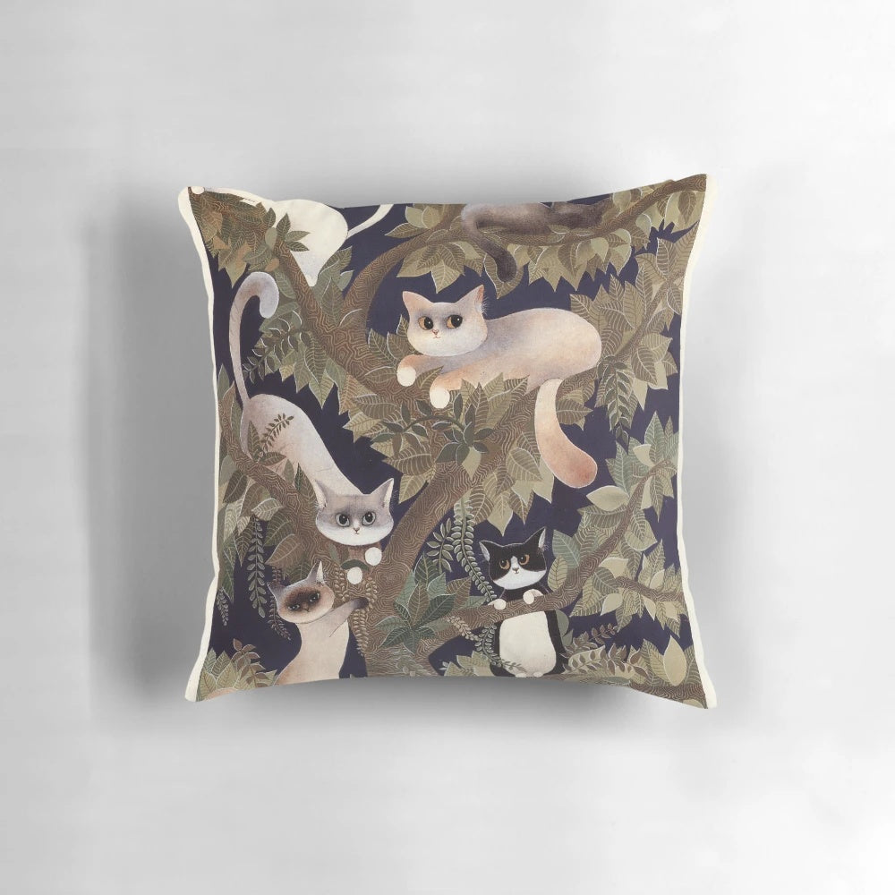 A beautifully designed pillow featuring a tree with whiskered cats in a harmonious symphony