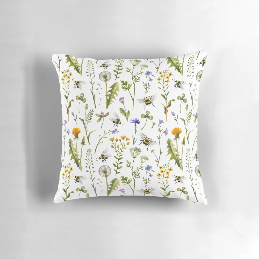 White pillow with an illustration of bees and wildflowers