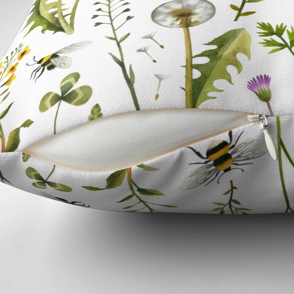 White pillow with an illustration of bees and wildflowers