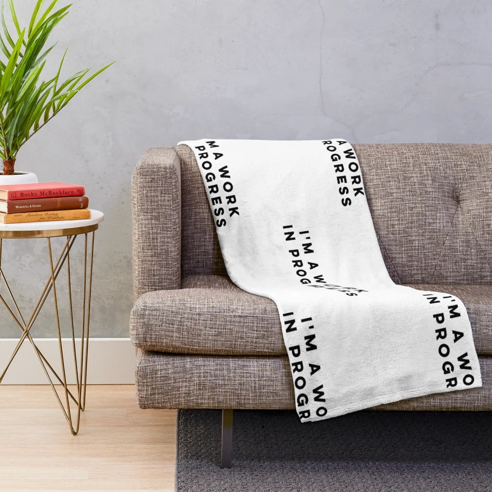Work in Progress" plush blanket with inspirational quote and colorful design