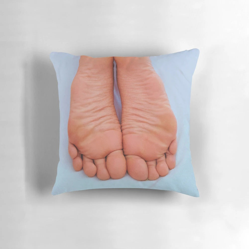 Close-up of wrinkled, pink soles on a plush pillow, perfect for foot fetish enthusiasts.