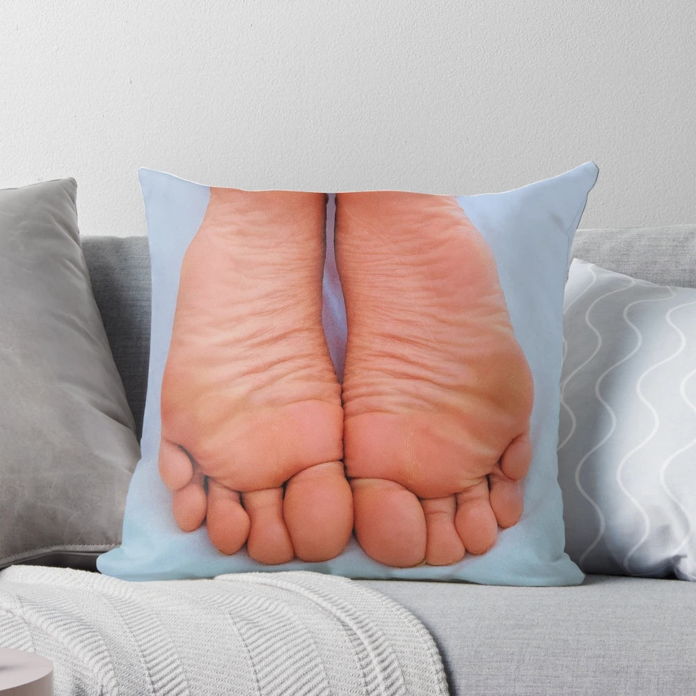 Close-up of wrinkled, pink soles on a plush pillow, perfect for foot fetish enthusiasts.