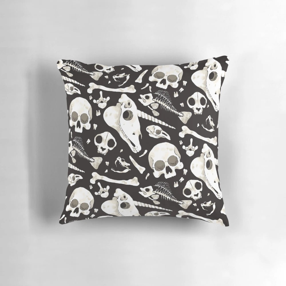 Decorative black and white pillow featuring a collage of skulls, bones, and other natural history curiosities.