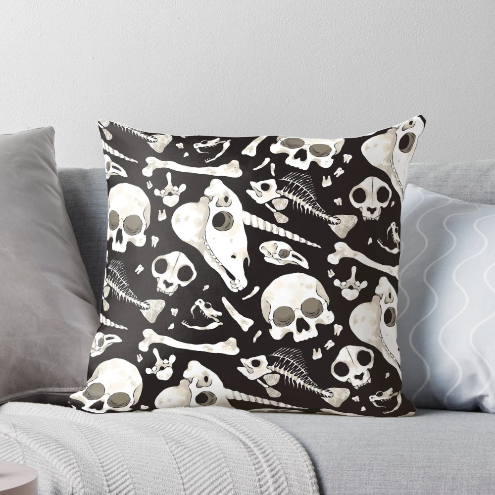 Decorative black and white pillow featuring a collage of skulls, bones, and other natural history curiosities.