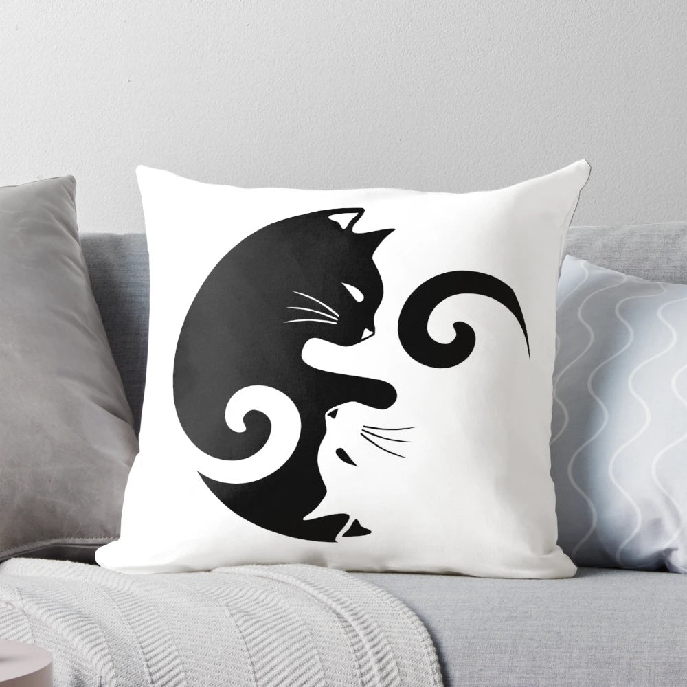 A black and white throw pillow featuring a yin yang cats design illustration